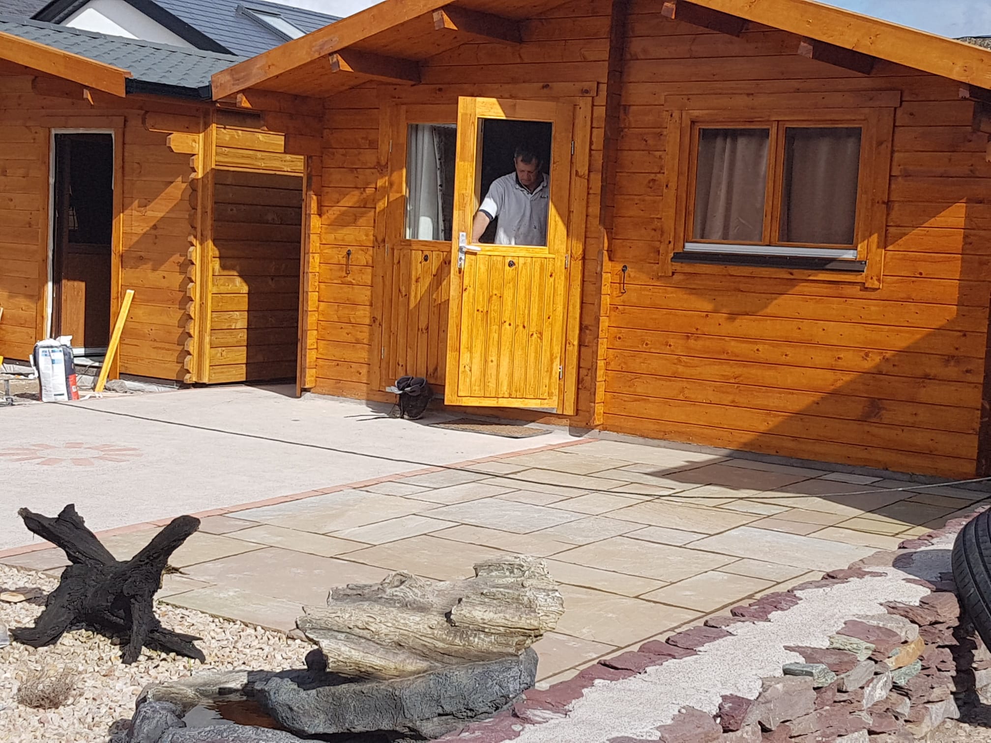 A worker coming out the front door of a newly constructed wooden home
