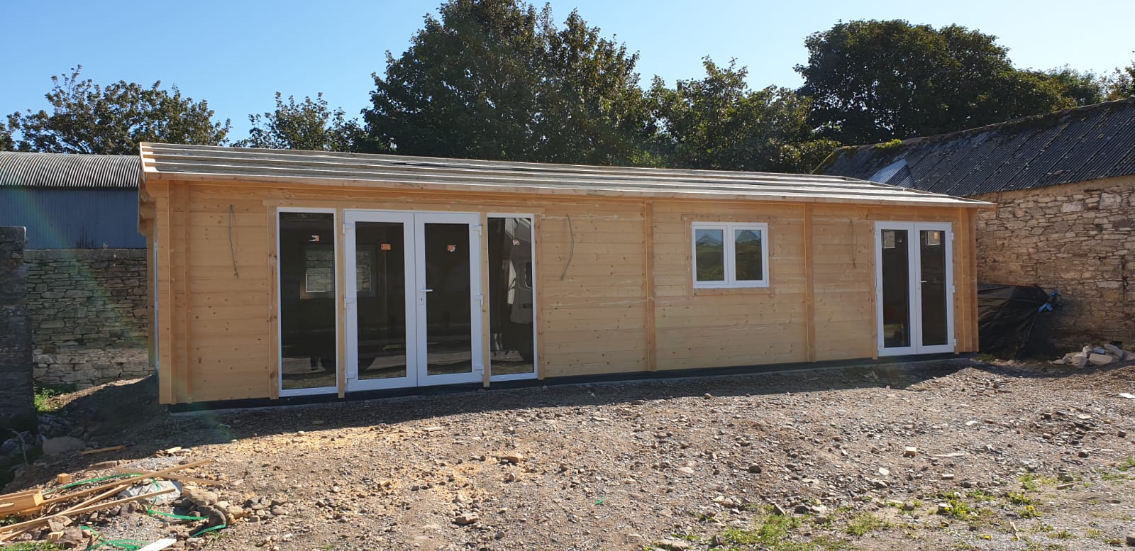 image of the side of a timber frame cabin built beside a house